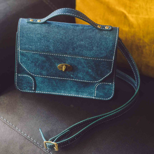 women's crossbody handbag in Italian leather closed on sofa with handle and strap