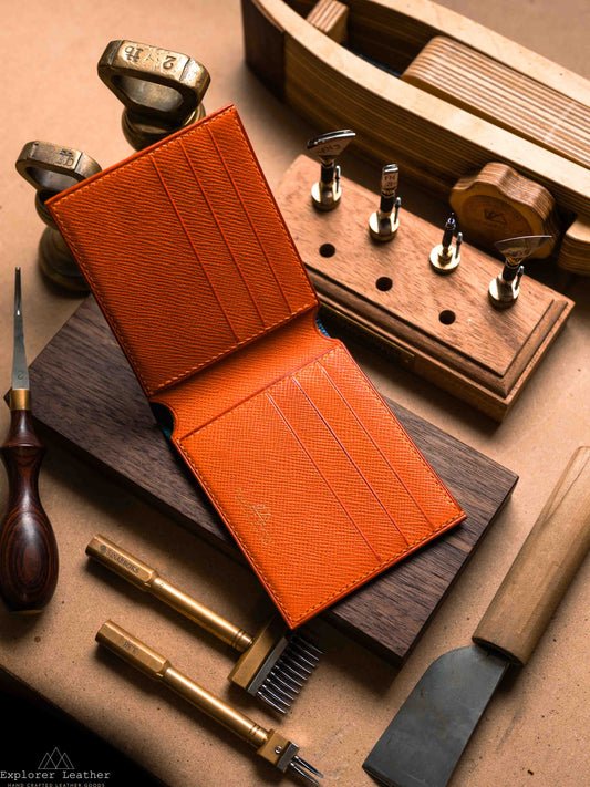 Open navy bifold wallet showing orange card slots
