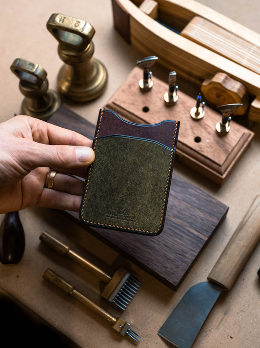 Three pocket leather card holder held to show its side profile