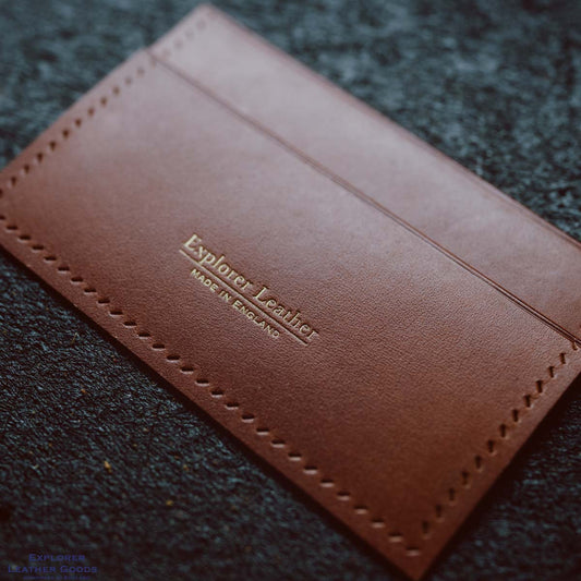 New minimalist Explorer Leather maker’s mark stamped in gold on brown leather, with Made in England beneath