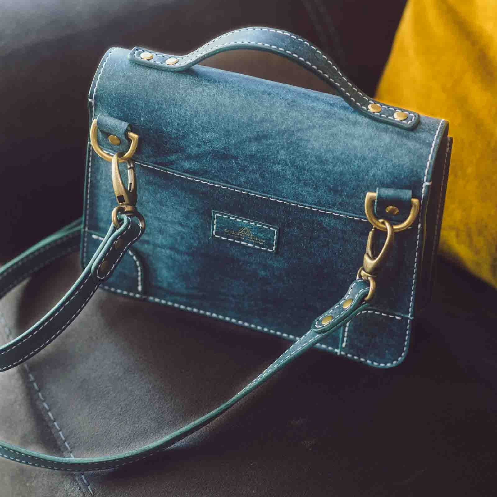 women's crossbody handbag in Italian leather closed on sofa showing the bag pocket of the handbag