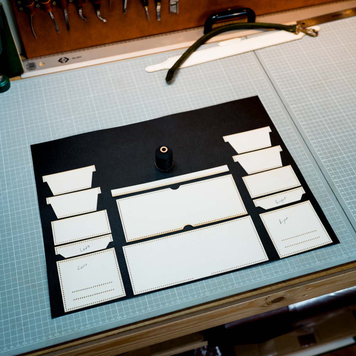 Set of white card templates on a black leather with tools in the background