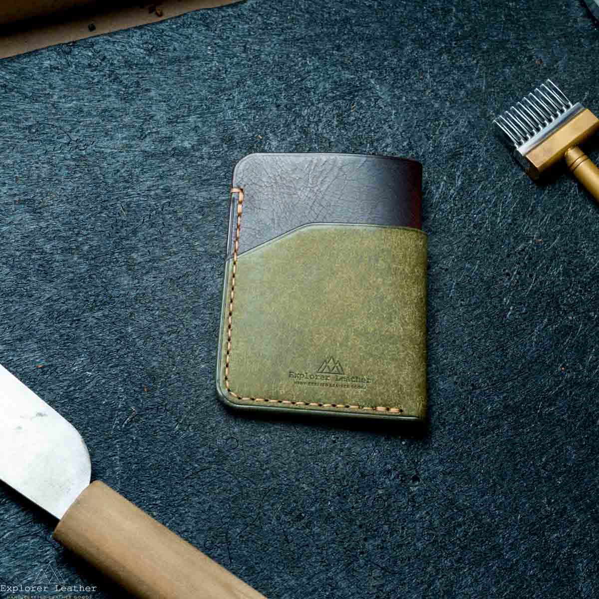 Leather wallet on a textured dark surface with tools around