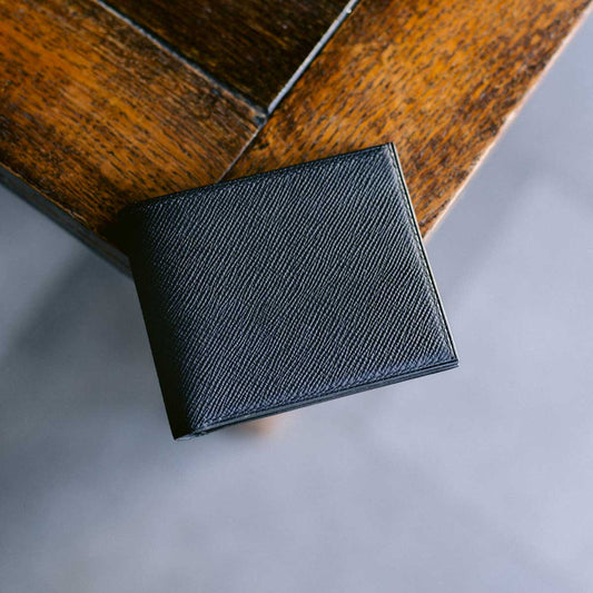 Black leather wallet on a wooden surface