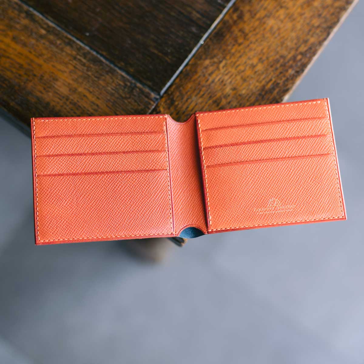 Blue and Orange leather wallet open on a wooden surface