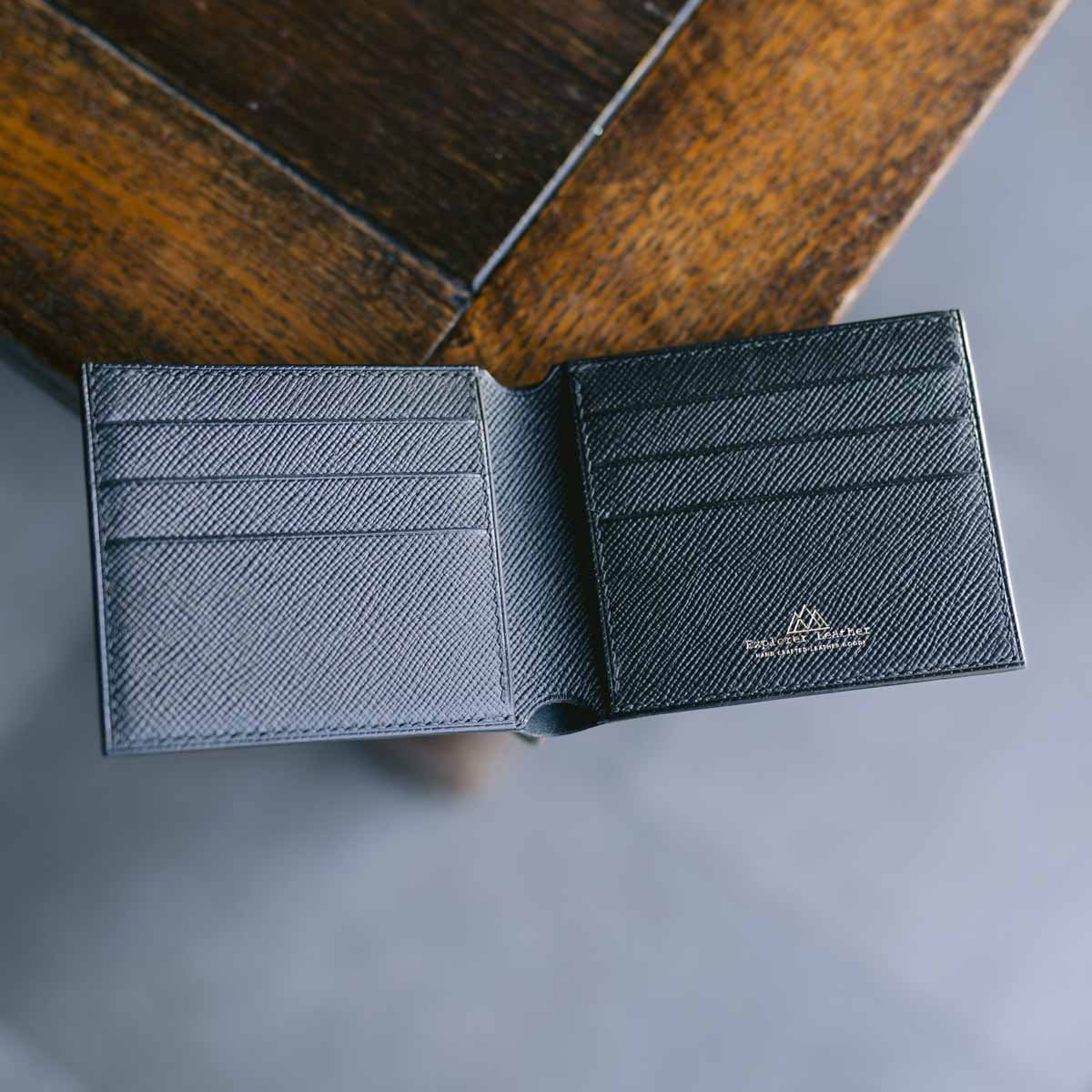 Black leather wallet with brand logo on a wooden surface