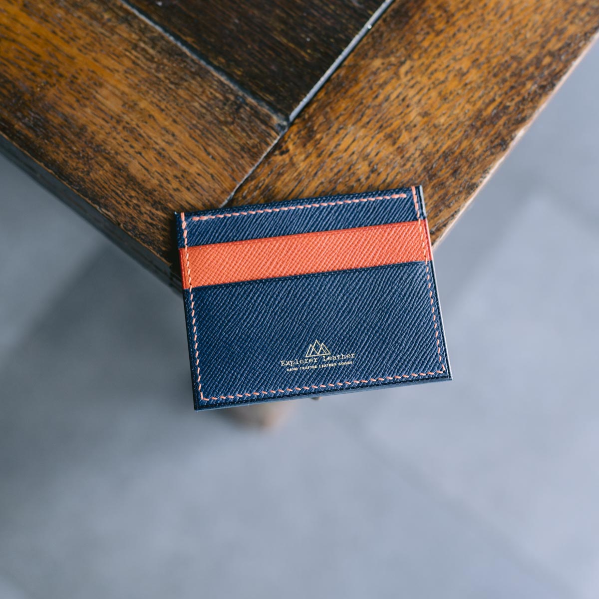 Blue and orange cardholder on a wooden surface