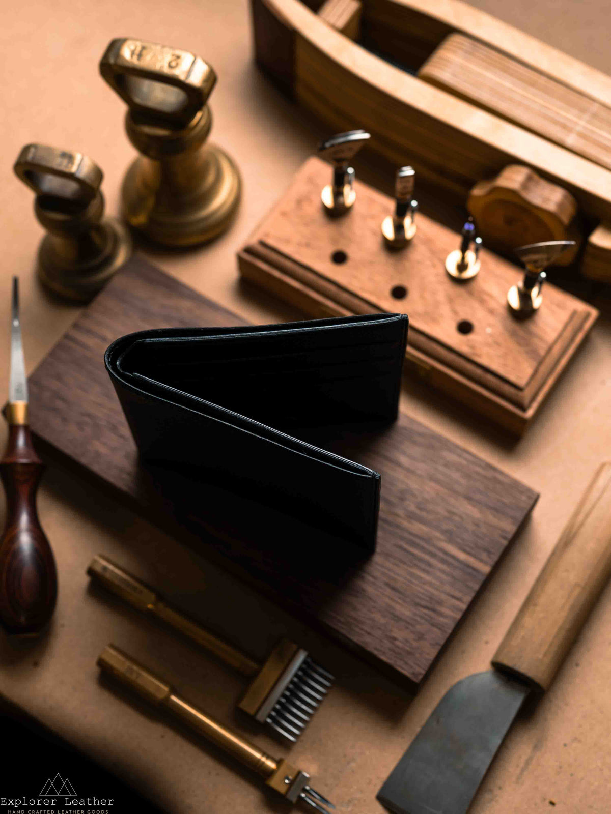 Black leather bifold wallet opened on a workbench