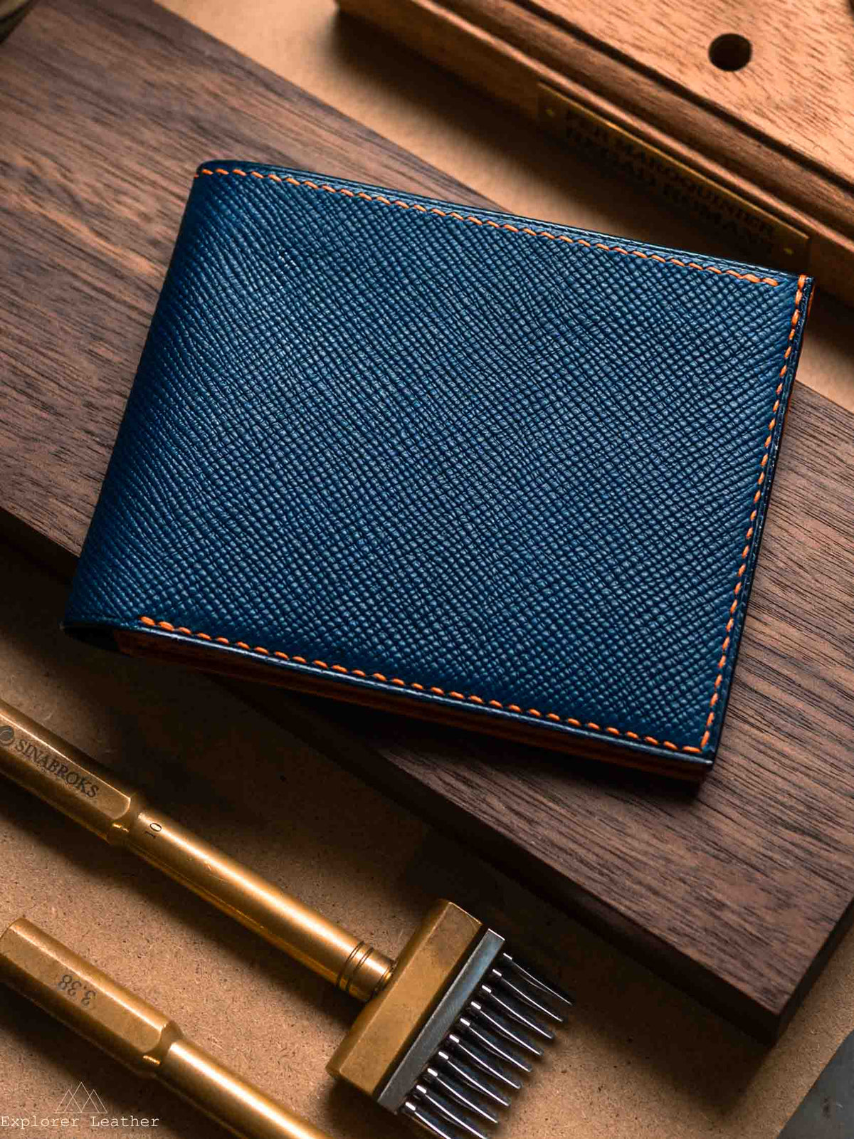 Close view of navy leather and hand stitching on bifold wallet