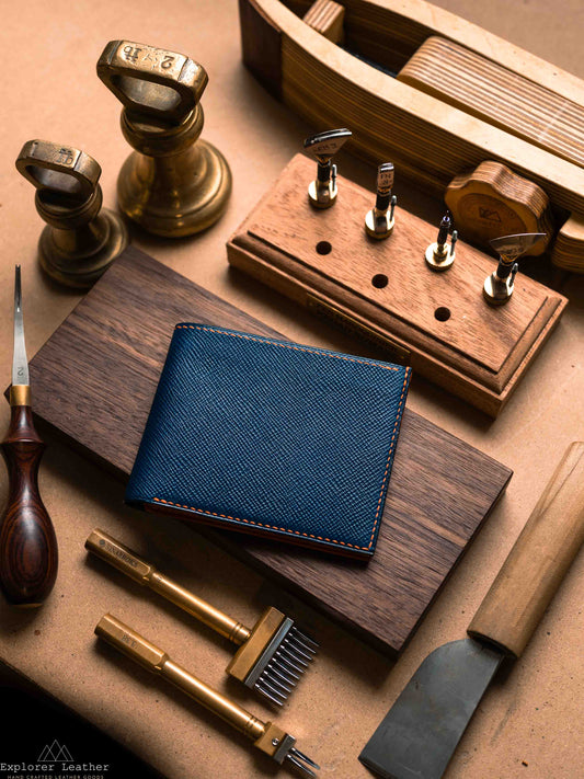 Closed navy leather classic bifold wallet on a workbench