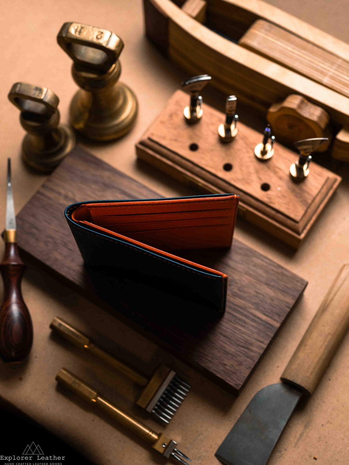 Side profile of navy bifold wallet with orange interior