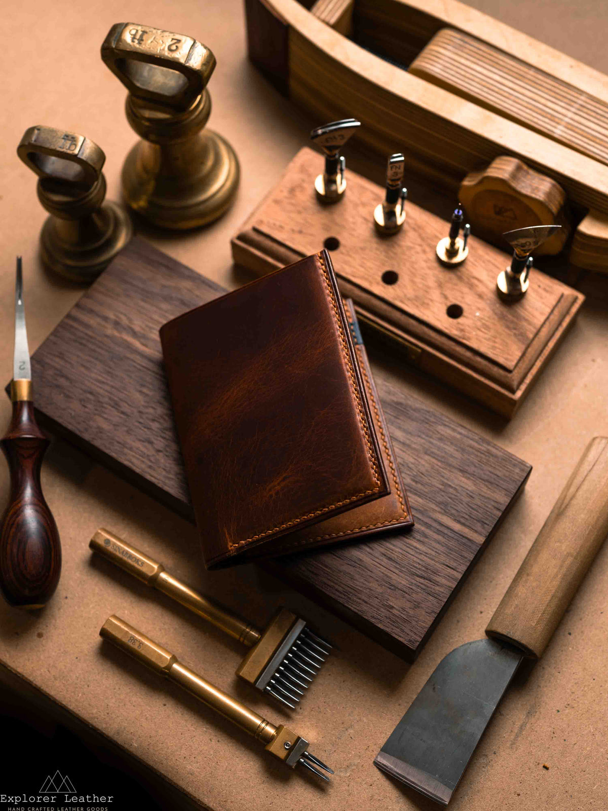 Closed Cognac and navy vertical bifold wallet on a workbench
