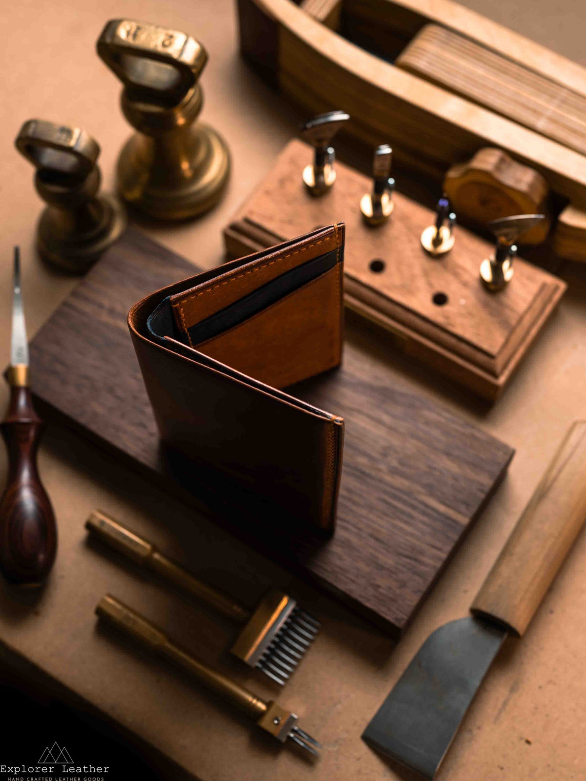 Cognac and navy vertical bifold leather wallet standing partly open