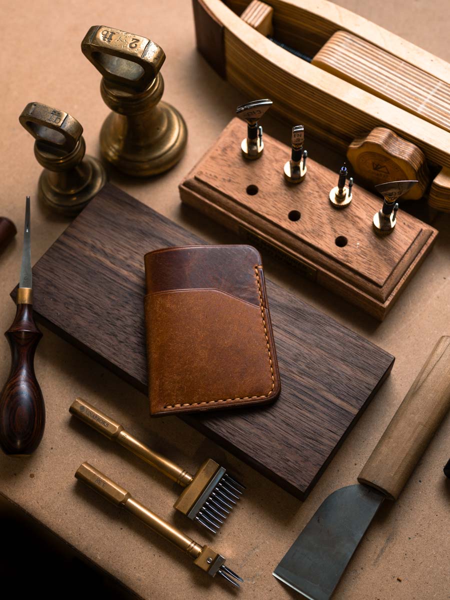 Three pocket Cognac leather card holder on a workbench