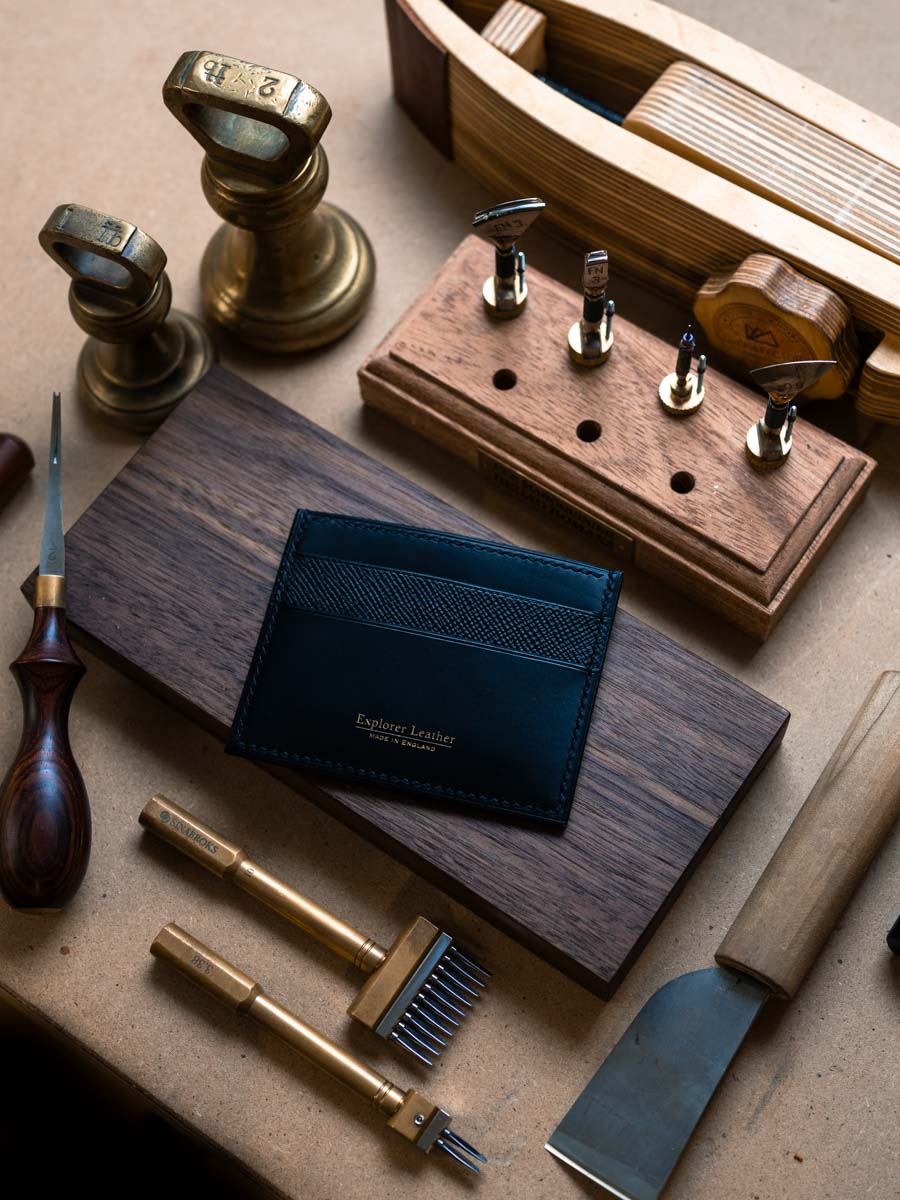 Navy five pocket leather card holder on a workbench