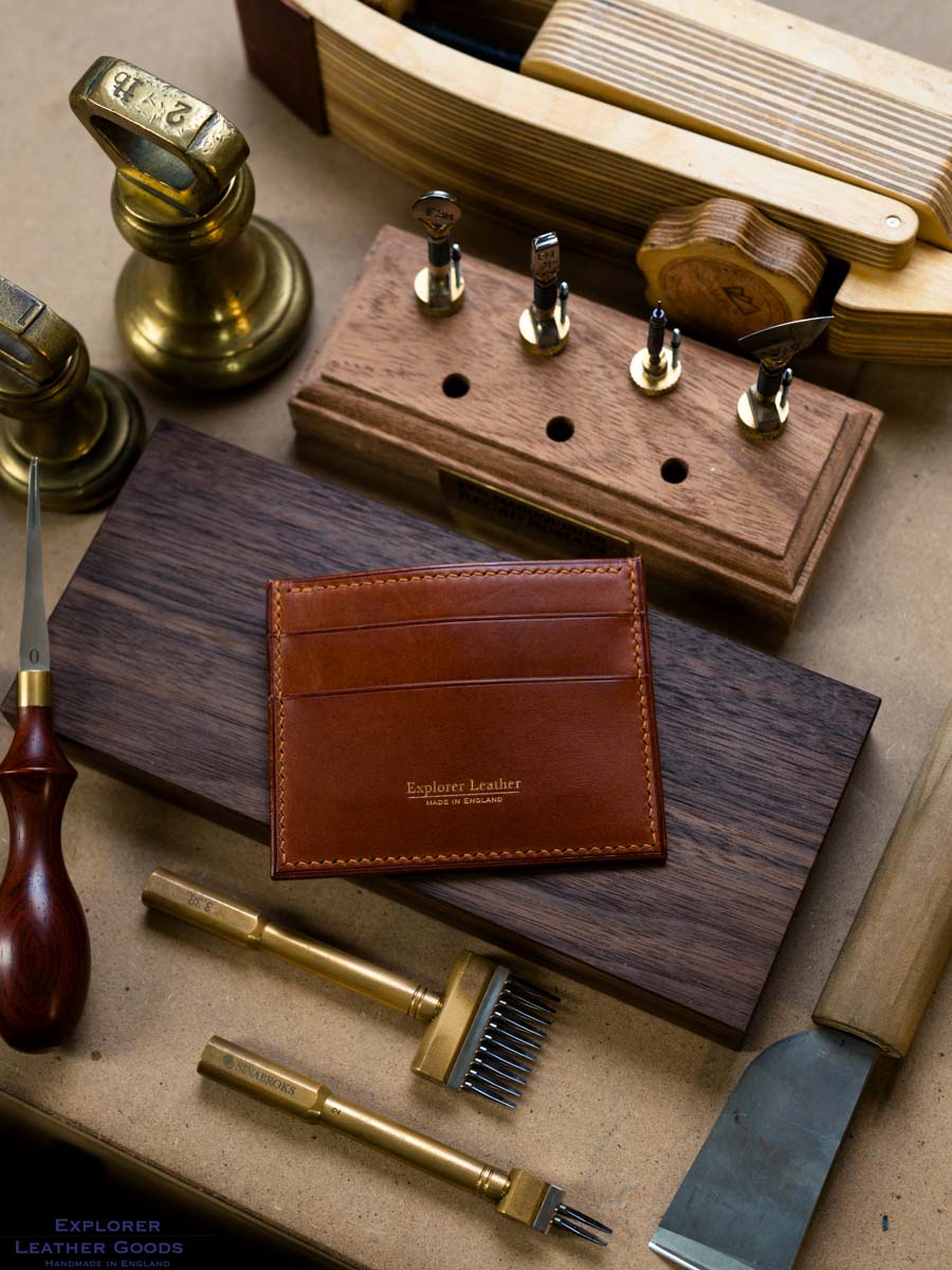 Cognac Buttero five pocket leather card holder on a workshop bench with gold Explorer Leather maker’s mark