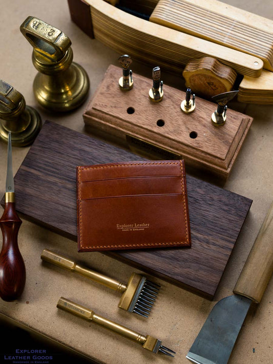 Cognac Buttero five pocket leather card holder on a workshop bench with gold Explorer Leather maker’s mark